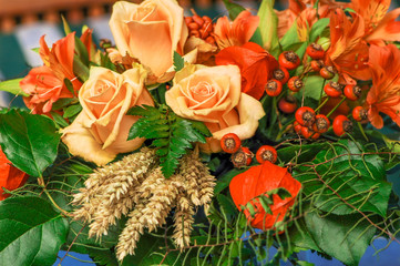 Herbstlicher Blumenstrauß mit Rosen, Hagebutten und Getreide