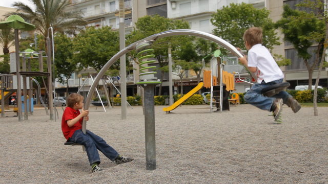 Children riding a swing on the playground