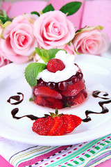 Tasty jelly dessert with fresh berries, on pink roses