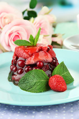 Tasty jelly dessert with fresh berries, on bright background