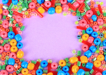 Different colorful beads on purple background