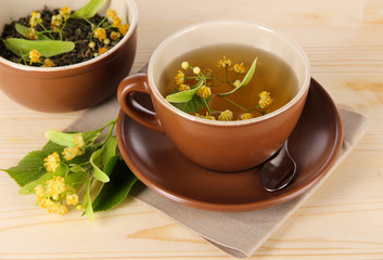 Cup of tea with linden on napkin   wooden table