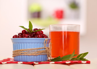 Glass of cranberry juice and ripe red cranberries in bowl