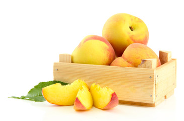Ripe sweet peaches in wooden crate, isolated on white