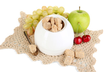 Unrefined sugar in white sugar bowl on grey background