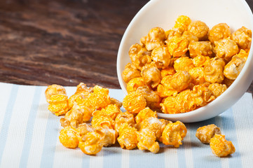 caramelised and cheddar flavoured pop corn on a bowl