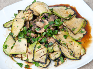 Slices of zucchini and mushrooms grilled in a sauce
