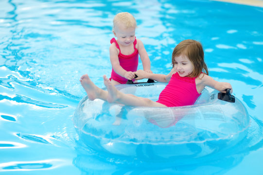 Little sisters having fun in a pool