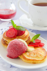 Pancakes with strawberries, strawberry sorbet and vanilla sauce.
