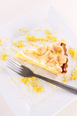 Lemon Meringue Tart on a plate decorated with lemon peel
