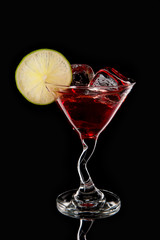 Red martini cocktail with ice cubes and lime
