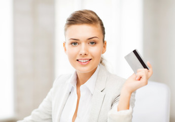smiling businesswoman showing credit card