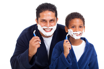playful little boy shaving with father