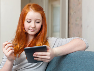 Teenager reads e-reader or tablet computer