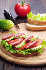 Sandwiches with sausage, lettuce, tomato and cucumber