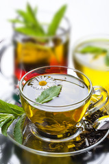 Cup with green tea and green leaves.