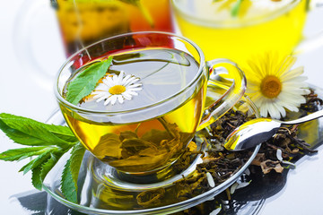 Cup with green tea and green leaves.