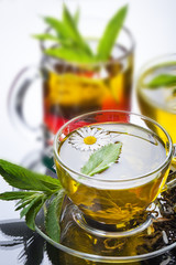 Cup with green tea and green leaves.