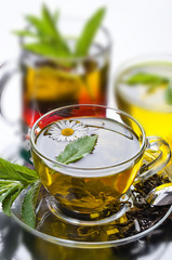Cup with green tea and green leaves.