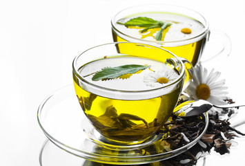 Cup with green tea and green leaves.