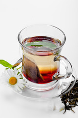 Cup with green tea and green leaves.