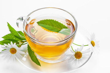 Cup with green tea and green leaves.