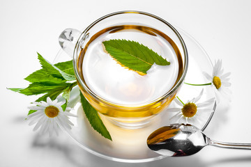 Cup with green tea and green leaves.