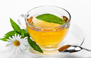 Cup with green tea and green leaves.