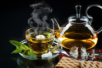 Cup with green tea and green leaves.
