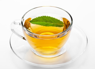 Cup with green tea and green leaves.