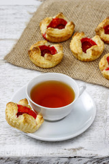 Cup of tea and small cakes on wooden rustic table