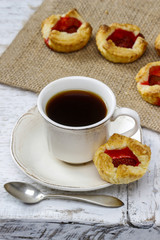 Cup of coffee and small cakes on wooden rustic table