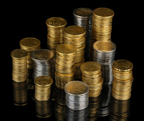 Many coins in columns isolated on black