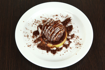 Chocolate dessert on big plate on wooden table