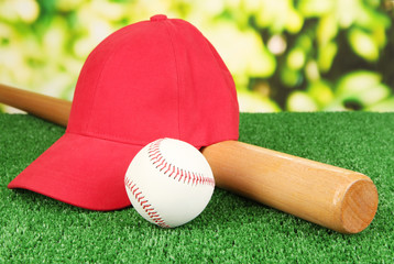 Red peaked cap on grass on natural background