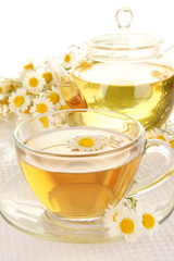 Cup of herbal tea with camomiles close up