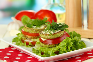 Tasty roasted marrow and tomato slices with salad leaves,