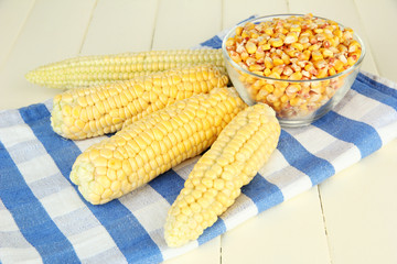 Fresh and dried corn on wooden background