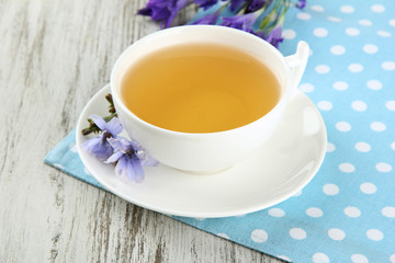 Cup of tea with chicory, on wooden background