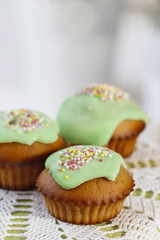Muffins with green icing and colorful sprinkles. Copy space, sel
