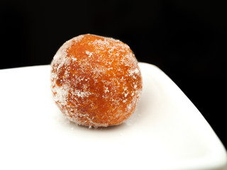 Donut ball, with sugar, on white plate