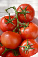 Wet whole tomatos arranged in the bowl