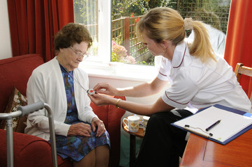 Healthcare visitor helping an elderly lady alarm