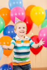 Obraz premium smiling child boy with balloons on birthday party