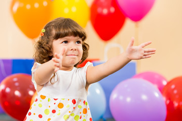 Fototapeta na wymiar smiling child girl with balloons on birthday party