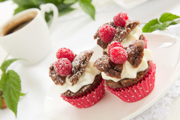 Chocolate muffins with raspberries and cream.