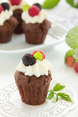 Chocolate muffins with raspberries and cream.