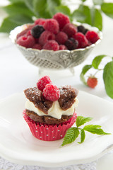 Chocolate muffins with raspberries and cream.