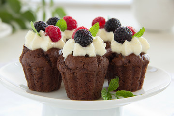 Chocolate muffins with raspberries and cream.