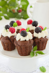 Chocolate muffins with raspberries and cream.